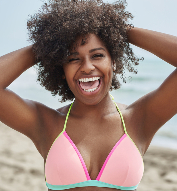 woman on beach with arms up