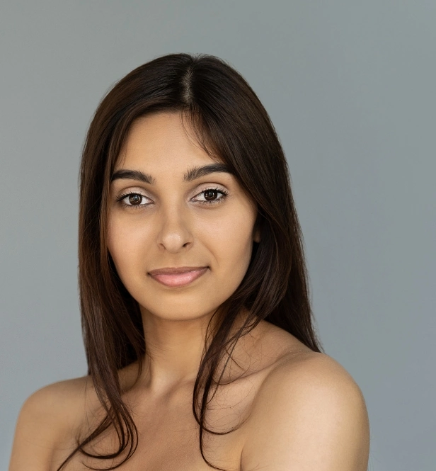 Woman with even skin confidently smiling at the camera