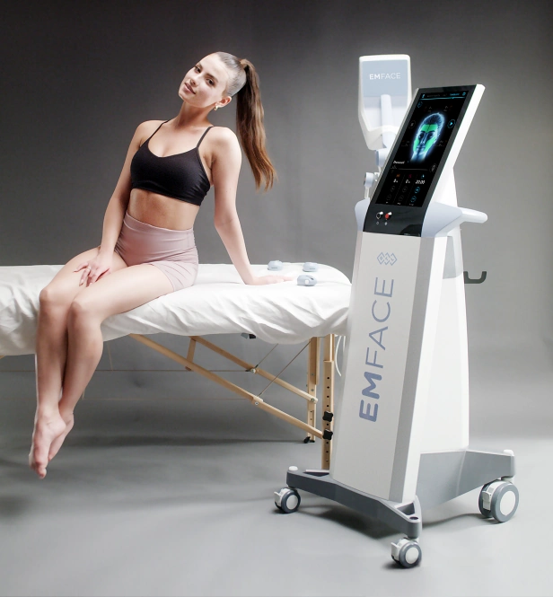 Model sitting on bed preparing for emface treatment