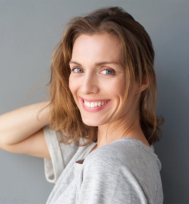 Woman in t-shirt smiling at camera against gray background