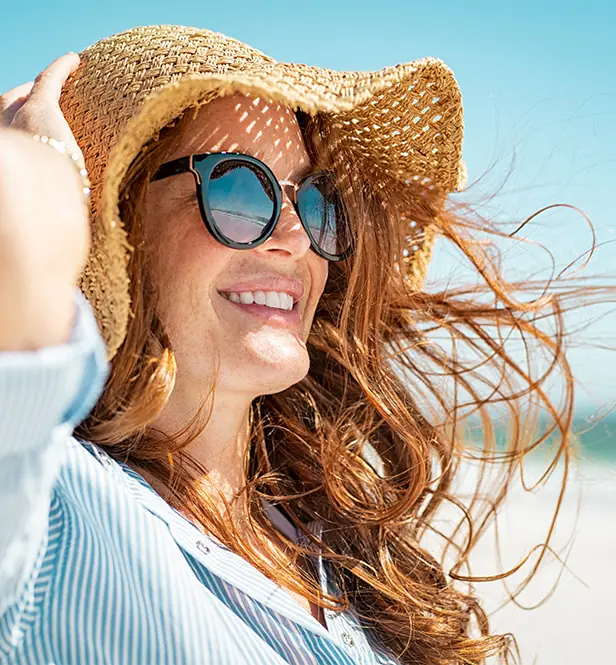 Lovely woman in straw hat on the beach