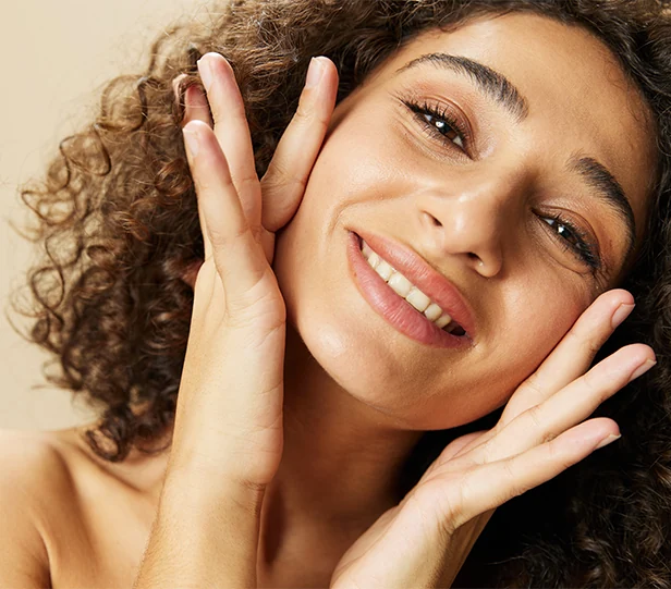 young woman touching hydrated, radiant skin